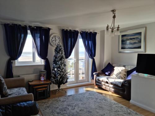 - un salon avec un arbre de Noël dans la fenêtre dans l'établissement Beach View Couples Retreat Aberavon Beach Direct Seafront, à Port Talbot