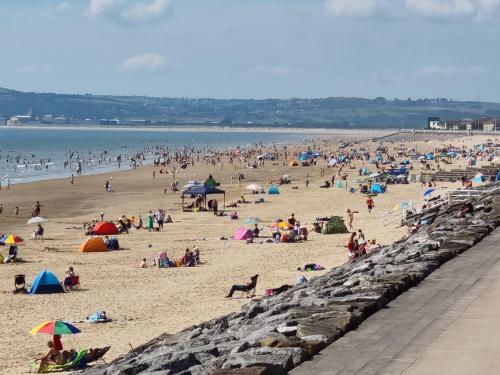a large group of people on a beach at Beach View Couples Retreat Aberavon Beach Direct Seafront panoramic Sea Views large driveway parking in Port Talbot