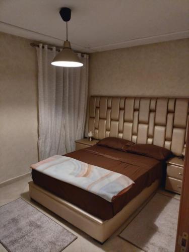 ein Schlafzimmer mit einem großen Bett mit einem großen Kopfteil in der Unterkunft Puerta Del Mar Apartment complex in Tangier