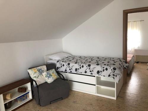 - une petite chambre avec un lit et une chaise dans l'établissement Apartman Kaja, à Zagreb