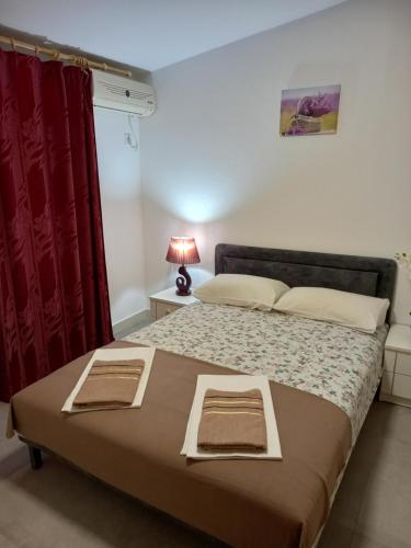 a bedroom with a large bed with a red curtain at Bugenvilija in Budva
