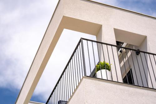 a building with a balcony with a potted plant at Panorama Suite Dora with Jacuzzi in Palit
