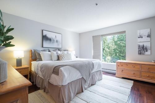 a bedroom with a large bed and a window at Greyhawk 123 by Outpost Whistler in Whistler