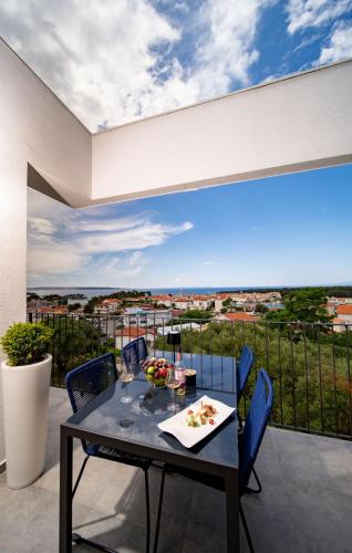 a table and chairs on a balcony with a view at Panorama Suite Dora with Jacuzzi in Palit