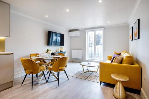 een woonkamer met een tafel en een gele bank bij Marble Arch Suite 5-Hosted by Sweetstay in Londen
