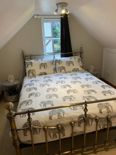 a bedroom with a bed with a bedspread with elephants on it at Little Nest EV Point in Wadebridge