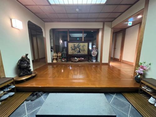 a room with a wooden floor and a room with vases at Fukuro no Oyado Shinkan - Vacation STAY 59589v in Fuefuki