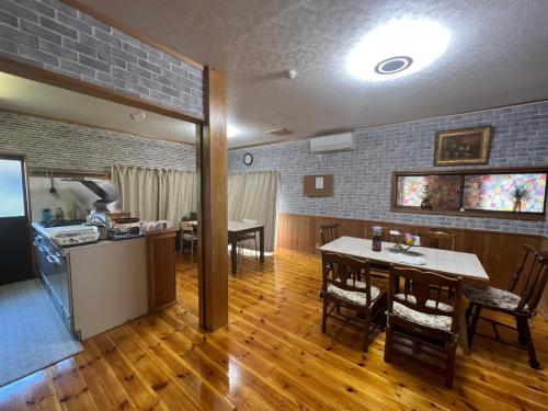 eine Küche und ein Esszimmer mit einem Tisch und Stühlen in der Unterkunft Fukuro no Oyado Shinkan - Vacation STAY 59568v in Fuefuki