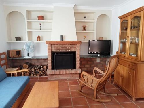 - un salon avec une cheminée et un canapé dans l'établissement CASA RURAL VELEFIQuE, à Velefique