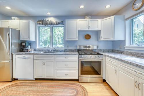 una cucina bianca con armadi bianchi e un tappeto di Fabulous Waterfront Home Midcoast Maine 