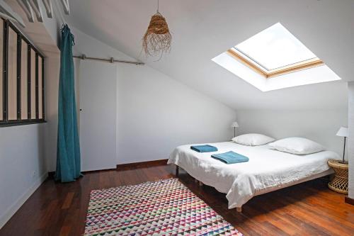 une chambre avec un lit et une lucarne dans l'établissement Duplex Carnon, à Carnon-Plage