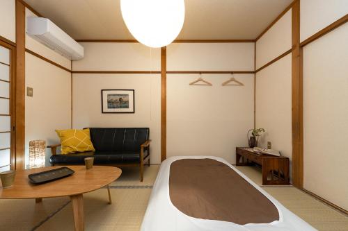 a room with a bed and a couch and a table at Kiyomizu Donguri-an - Vacation STAY 14648 in Kyoto