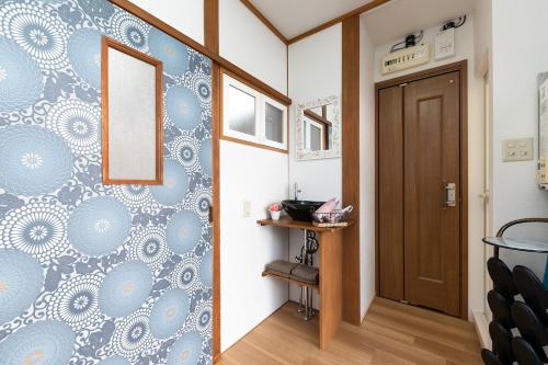 a hallway with a door and a wall with blue and white wallpaper at Kiyomizu Donguri-an - Vacation STAY 14648 in Kyoto