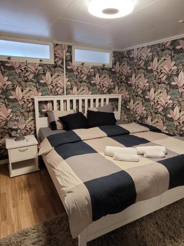 two beds in a bedroom with floral wallpaper at lägenhet i Borgholms villa in Borgholm