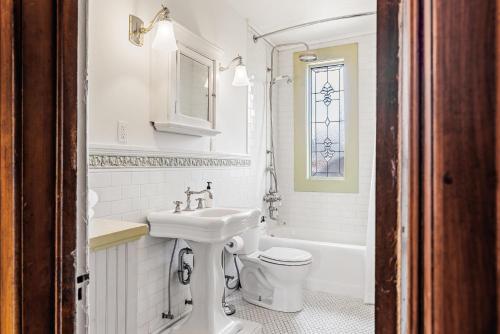 a white bathroom with a sink and a toilet at Chic Victorian Manor - Sleeps 10 - Congress Park in Denver