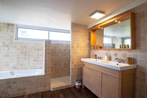 une salle de bain avec un lavabo, une baignoire et un miroir dans l'établissement Duplex Carnon, à Carnon-Plage