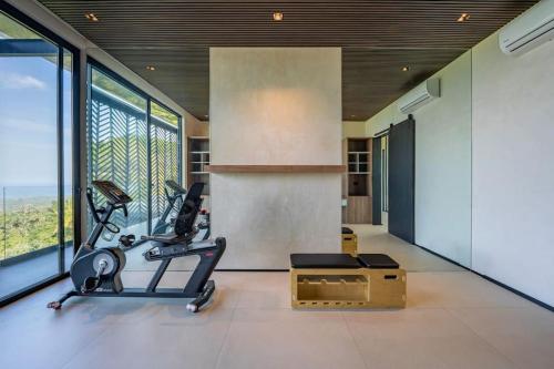 Zimmer mit einem Fitnessraum mit Laufband und großen Fenstern in der Unterkunft Casa Gaia in Nosara