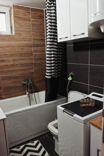 a small bathroom with a toilet and a bath tub at Stan na dan - Valikavali in Novi Pazar