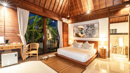 a bedroom with a bed and a desk in a room at Uma Kakul Villas in Tegalalang