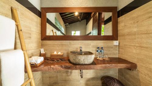 a bathroom with a sink and a mirror at Uma Kakul Villas in Tegalalang