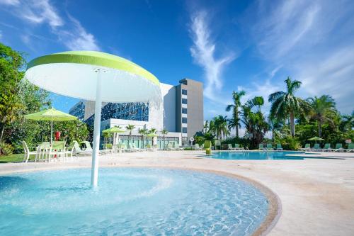 a pool with a fountain in the middle of a resort at Holiday Inn Mayaguez & Tropical Casino, an IHG Hotel in Mayaguez