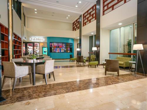 a lobby with a table and chairs in a building at Holiday Inn Mayaguez & Tropical Casino by IHG in Mayaguez