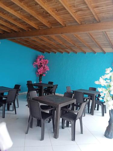 a room with tables and chairs and a blue wall at CABAÑA VALLE REAL STAR in Turbo
