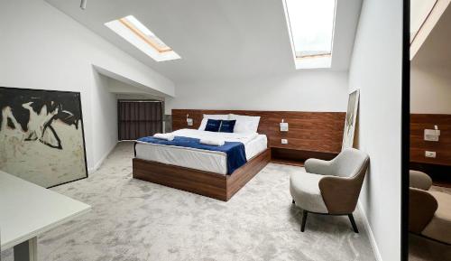 a bedroom with a bed and a chair at Nam Hotel in Prizren