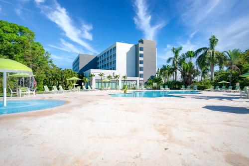 a resort swimming pool with a hotel in the background at Holiday Inn Mayaguez & Tropical Casino, an IHG Hotel in Mayaguez