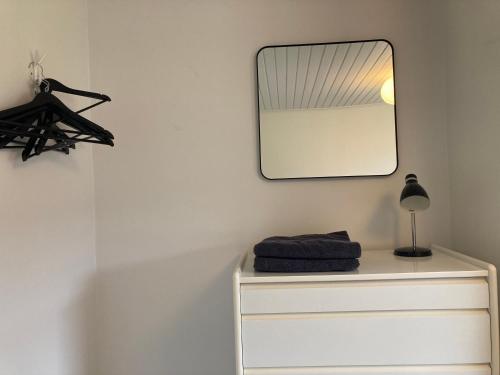 a mirror on a wall above a white dresser at Villa med private værelser delt badeværelse/køkken, viby sj. in Viby