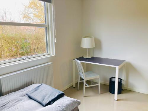 a bedroom with a desk and a bed and a window at Villa med private værelser delt badeværelse/køkken, viby sj. in Viby