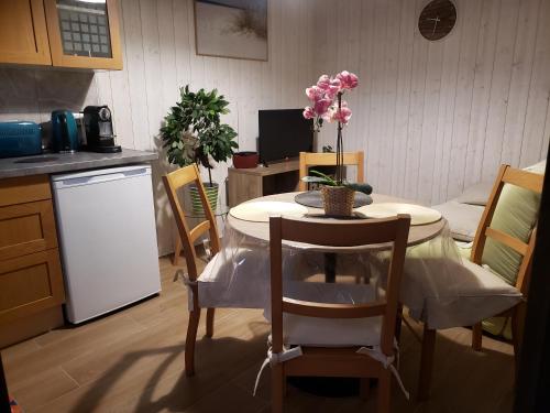 a kitchen with a table and chairs with a table and flowers on it at Détente à Mont-près-Chambord in Mont-près-Chambord