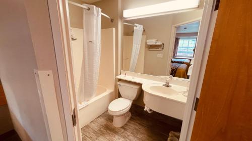 La salle de bains est pourvue de toilettes, d'un lavabo et d'une baignoire. dans l'établissement Royal Inn Midvale, à Midvale