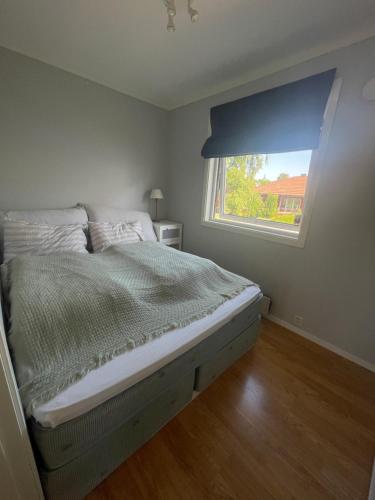 a bedroom with a large bed with a window at Leilighet ved Ladestien in Trondheim