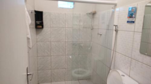 uma casa de banho com um chuveiro e um WC. em 102 Apartamento em Aracruz ES em Aracruz
