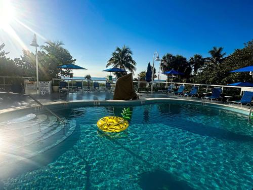 a person sitting next to a swimming pool at Best Western Plus Atlantic Beach Resort in Miami Beach