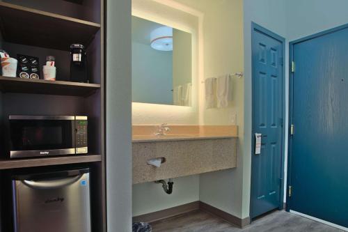 a small bathroom with a microwave and a sink at Comfort Inn & Suites Sierra Vista near Ft Huachuca in Sierra Vista