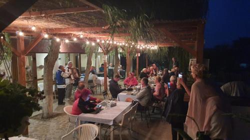 a group of people sitting at tables in a restaurant at Pensiunea 4 Salcii in Băltenii de Sus