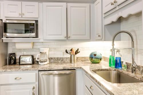 a kitchen with white cabinets and a sink at Pet-Friendly Jekyll Island Abode - Walk to Beach! in Jekyll Island