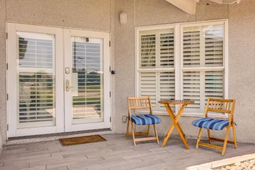 a patio with two chairs and a table and windows at Pet-Friendly Jekyll Island Abode - Walk to Beach! in Jekyll Island