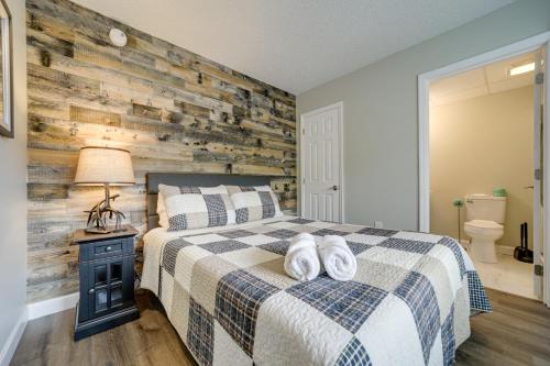 a bedroom with a bed and a wooden wall at Stylish Gatlinburg Condo with Pool Walk Downtown! in Gatlinburg