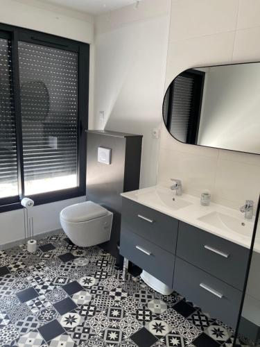 a bathroom with a toilet and a sink and a mirror at La résidence du Franc Palais 2 in Joue-les-Tours