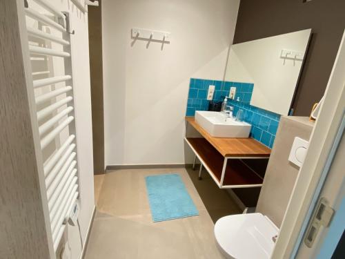 a bathroom with a sink and a toilet and a mirror at B&B Les Autres Sens in Villers-la-Ville