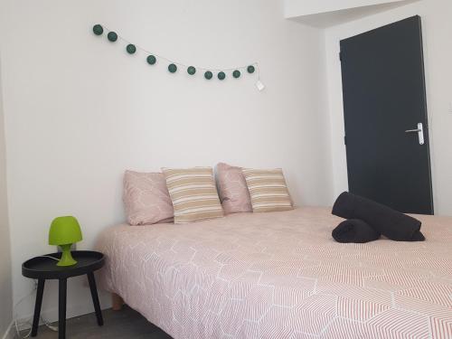 a bedroom with a bed and a green lamp on a table at Appartement numéro 1 diamant in Saint-Junien