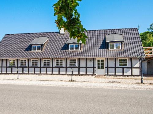 a house with a black roof and a fence at 10 person holiday home in Auning-By Traum in Auning