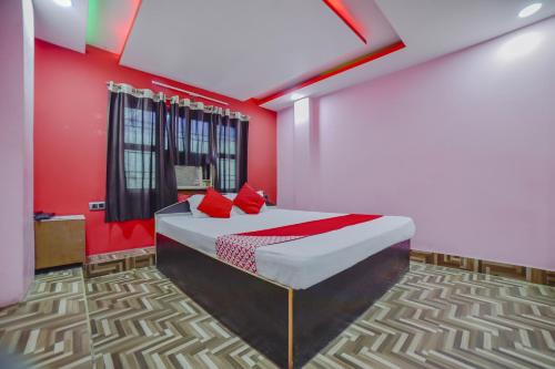 a bedroom with a bed with red walls at OYO Flagship 80963 The Subhadra in Muzaffarpur