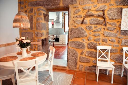 une cuisine et une salle à manger avec un mur en pierre dans l'établissement Casa da Igreja, à Ponte da Barca