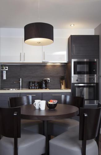 a kitchen with a wooden table and black cabinets at EPIC Apart Hotel - Duke Street in Liverpool
