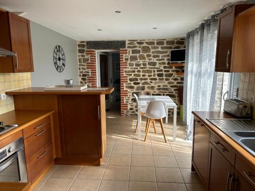 a kitchen with a table and a chair in it at La maison du Chêne 2 in Miniac-Morvan