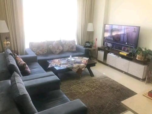 a living room with a couch and a tv at Moca hostel in Dubai
